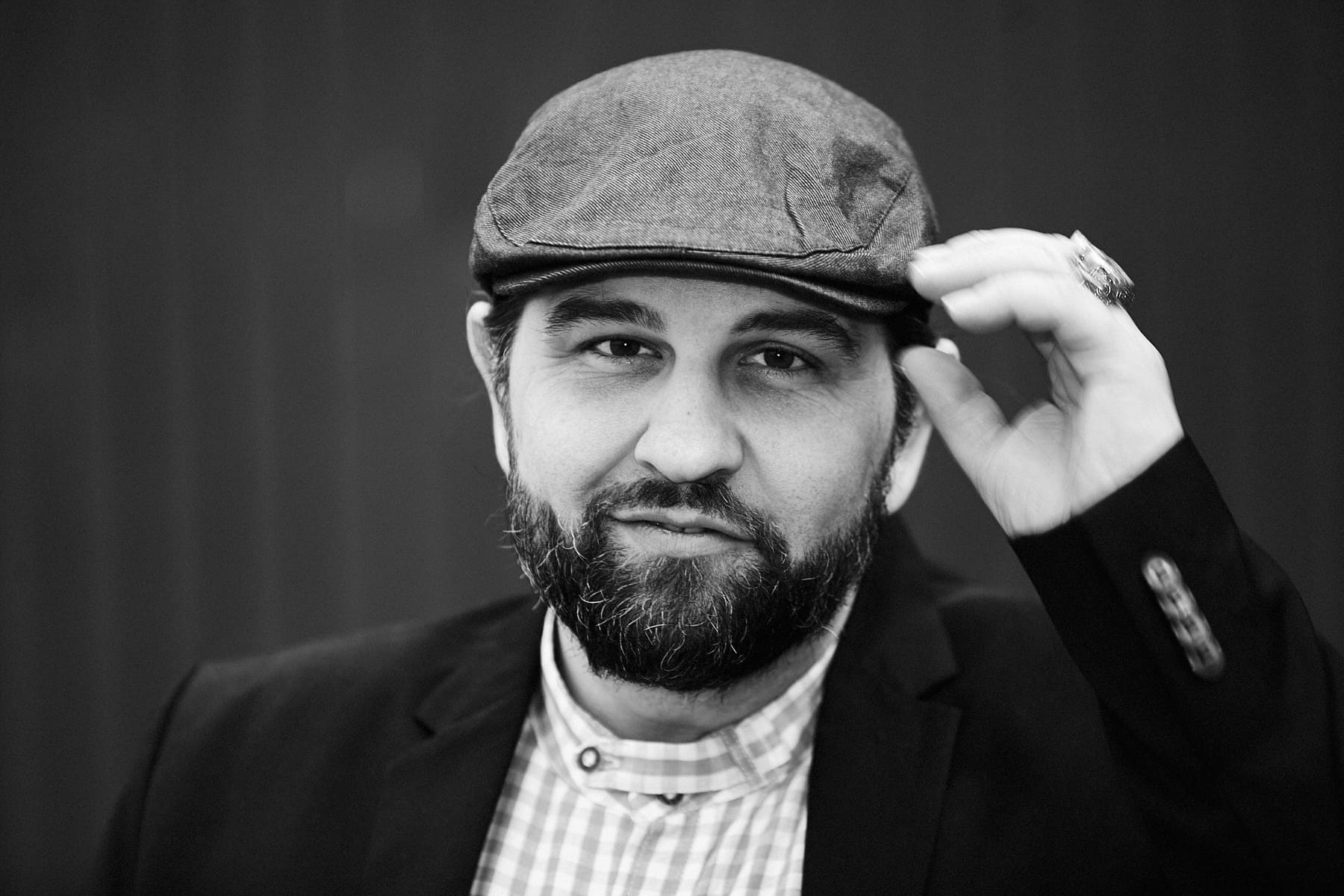 Mann mit grauer Mütze und Bart, dynamisches Schwarz-Weiß-Portrait mit mobilem Studio Berlin.